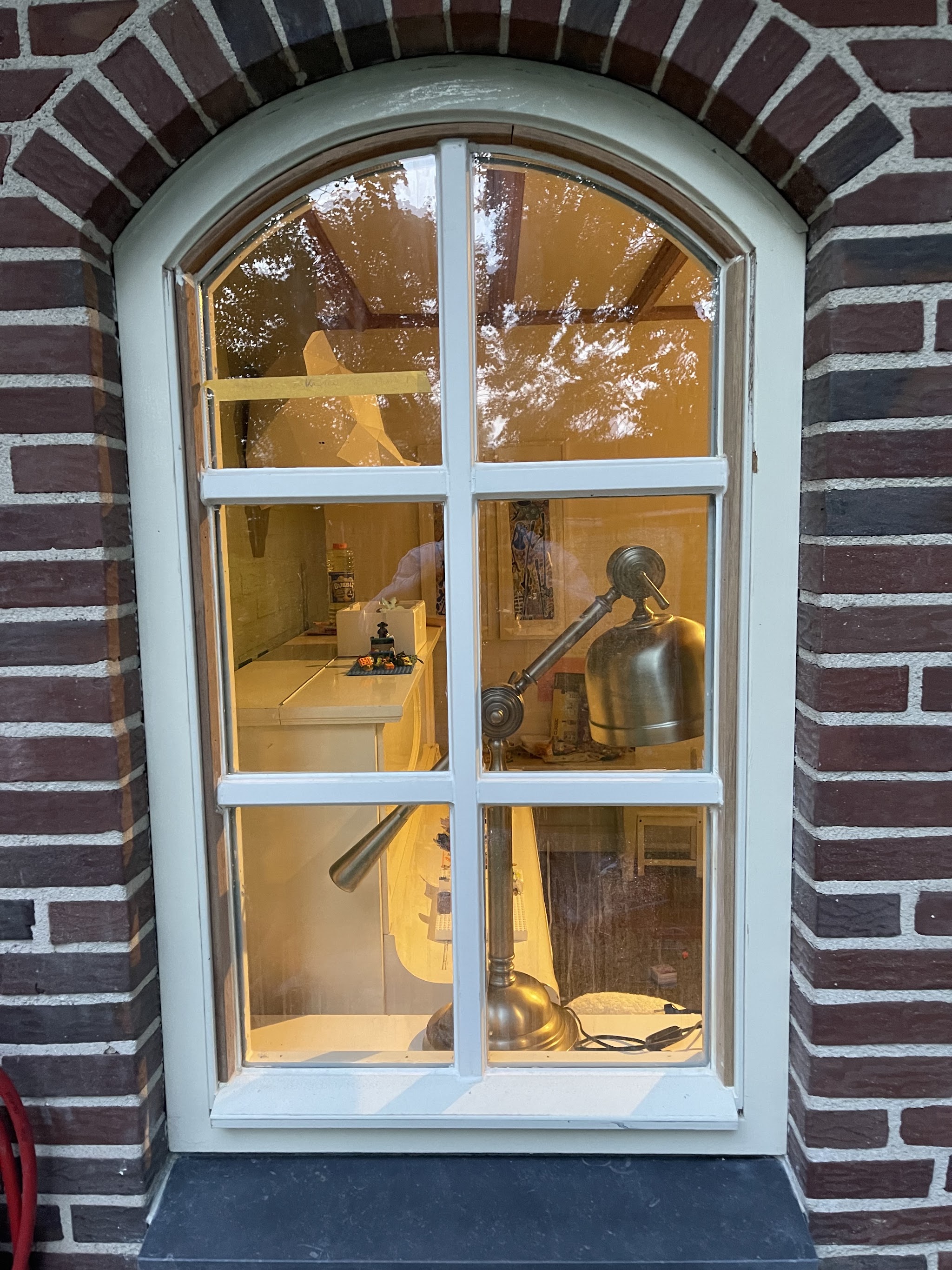 Fris wit geschilderd boogkozijn in een bakstenen gevel