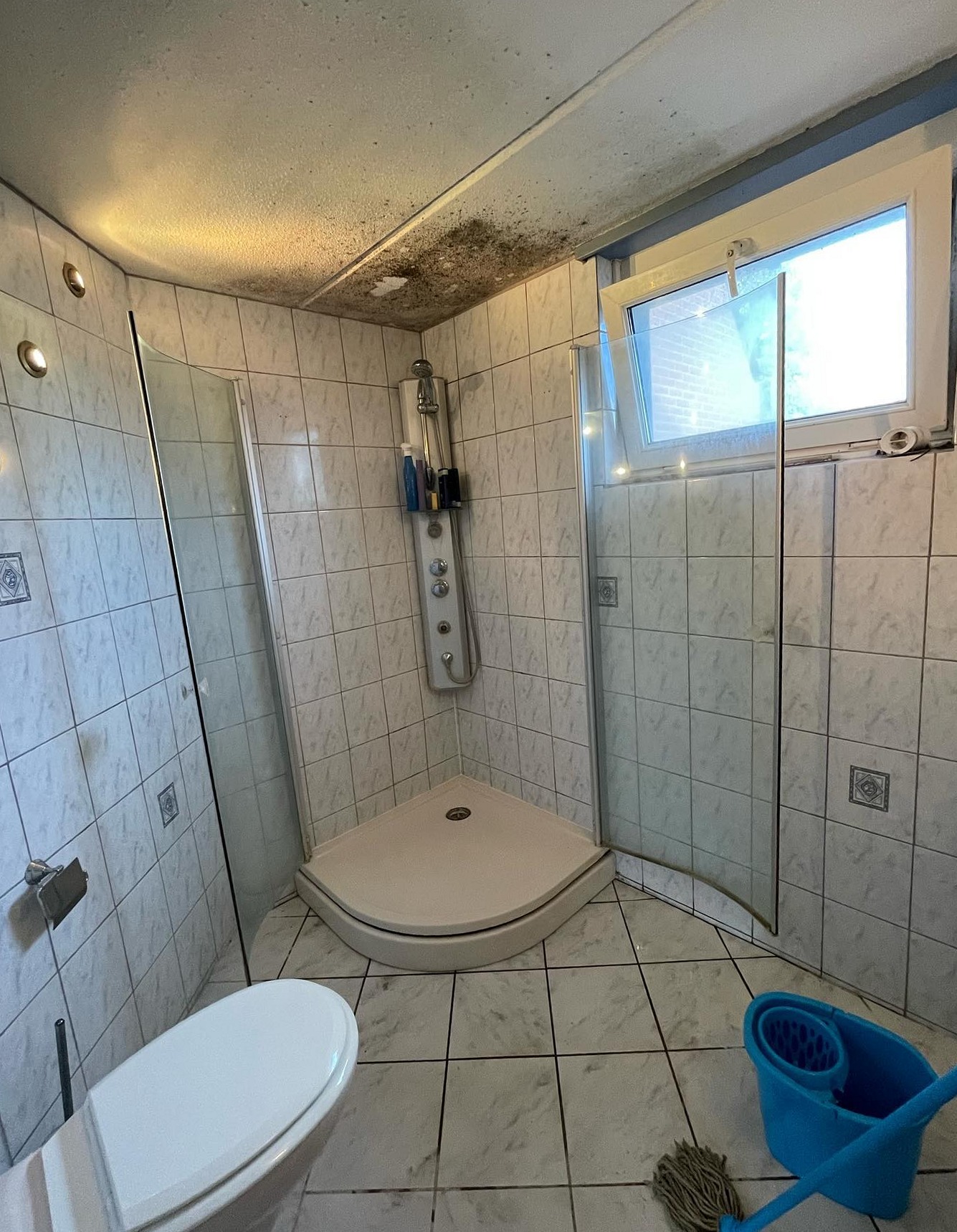 Oude betegelde douche voor de renovatie