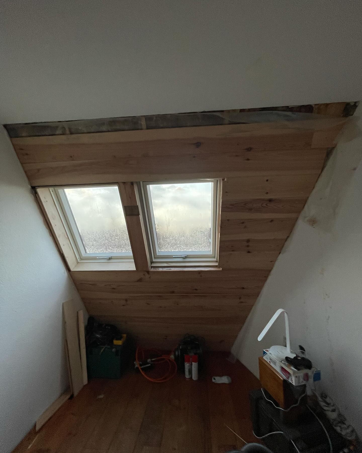 Zolder waarvan de binnenzijde van de gevel is afgetimmerd met hout, met twee dakramen